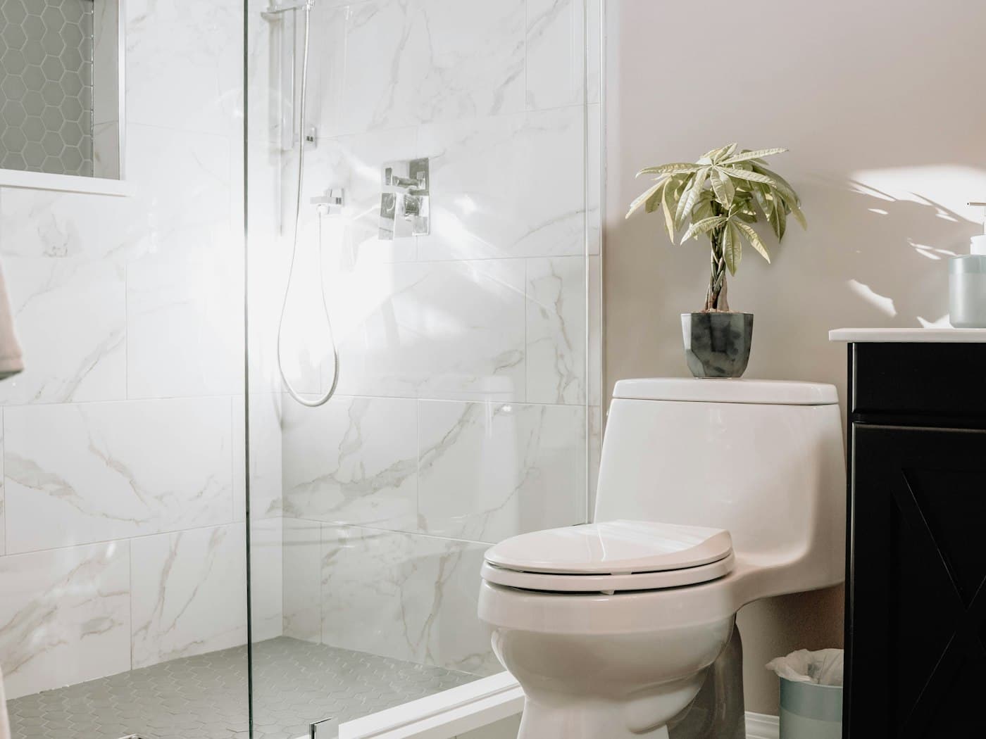 Freshly deep cleaned bathroom with marble tiling and a glass shower screen