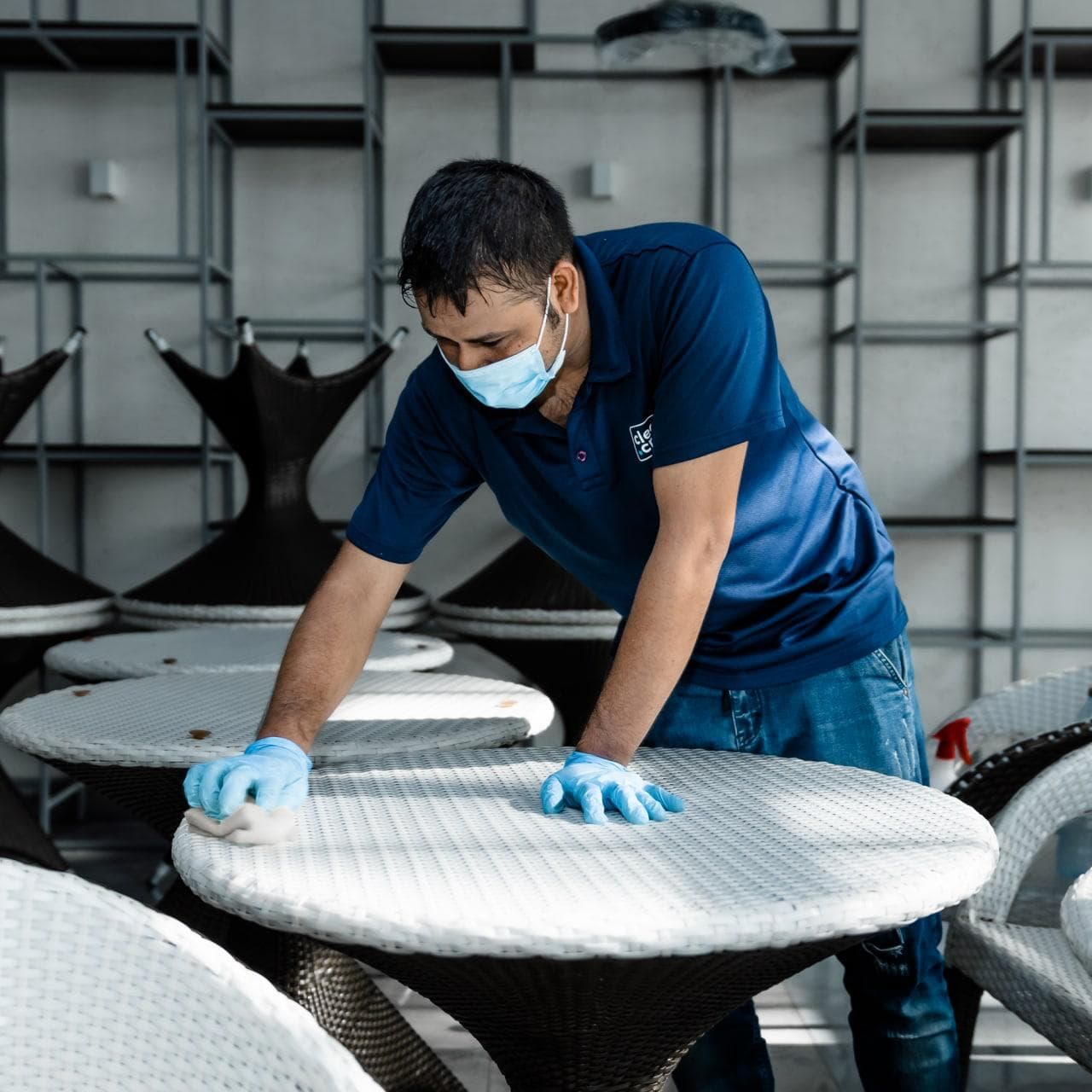Clean Crew technician wiping down outdoor rattan furniture