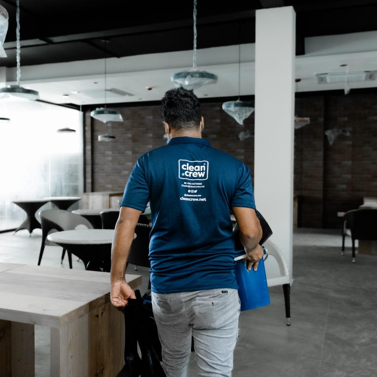Clean Crew technician carrying equipment through a restaurant
